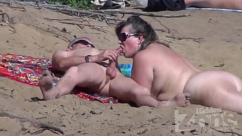 Porno amatori cum îi suge pula pe o plajă de nudiști